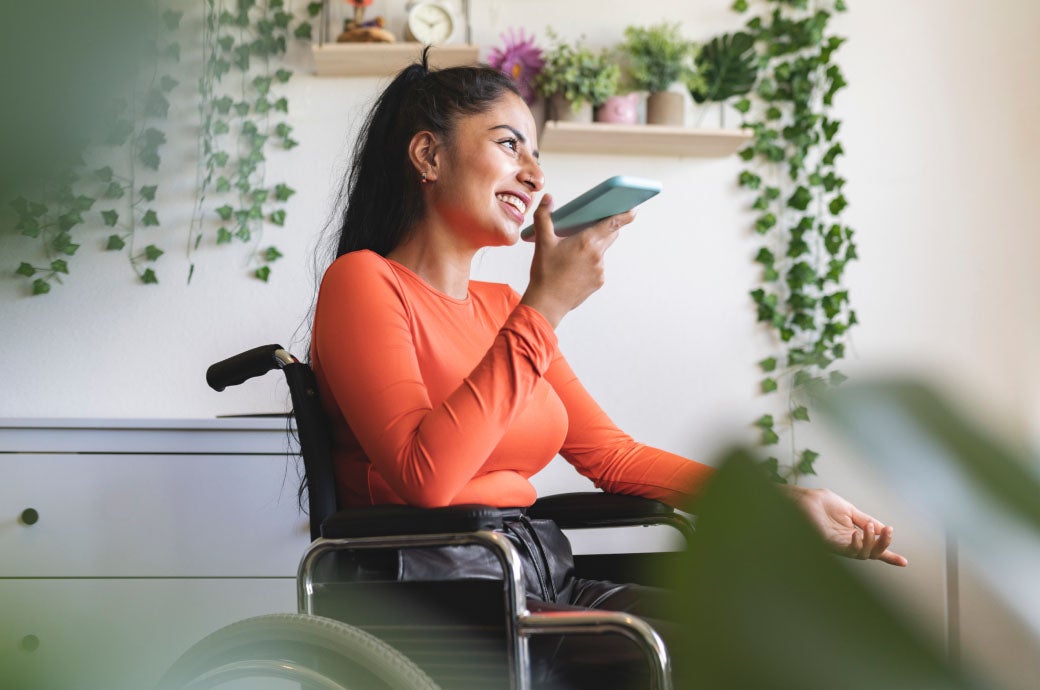 Young woman in a wheelchair smiling while she speaks on a cell phone