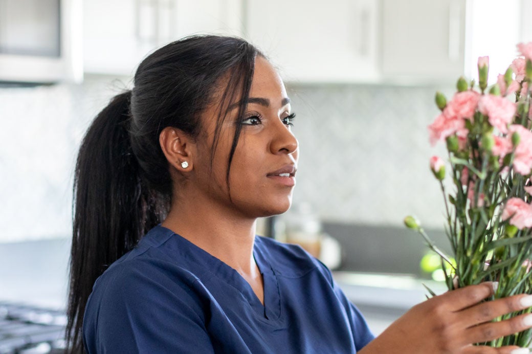 Healthcare provider in scrubs concentrating on a task.