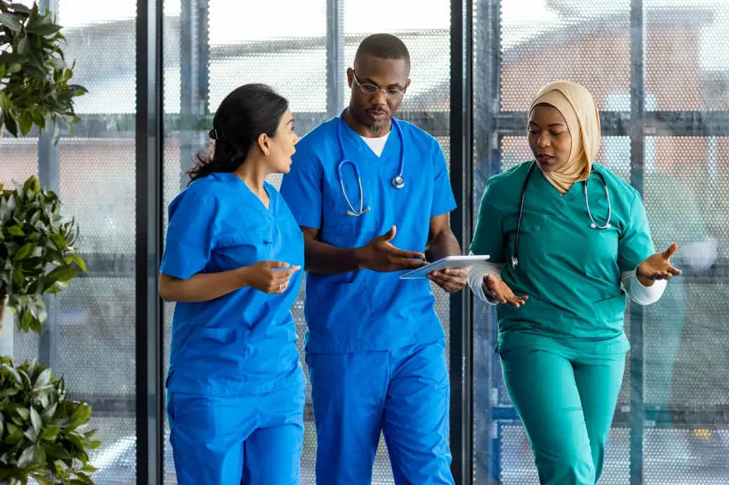 Three healthcare workers walking and talking