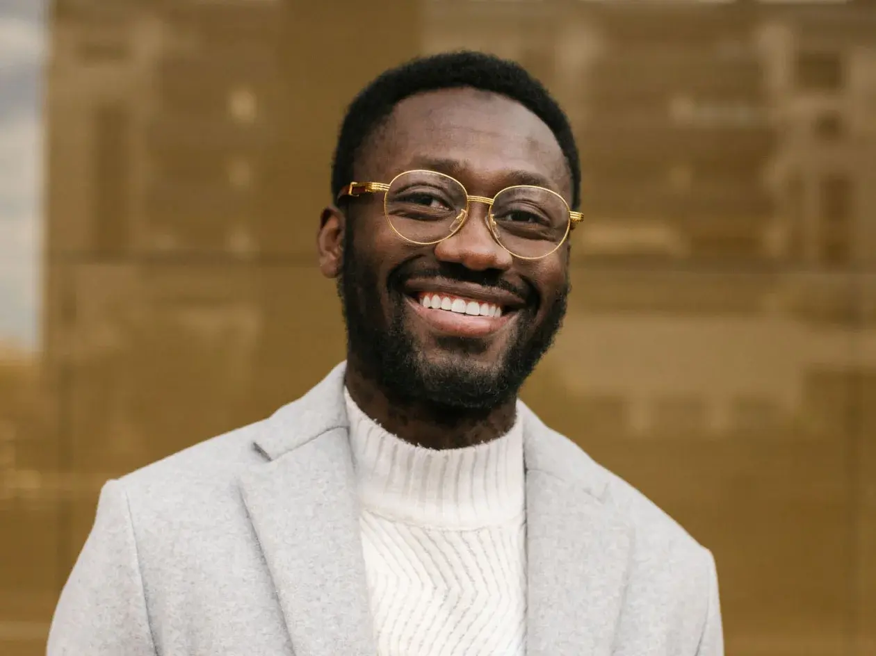 Headshot of smiling man wearing wire framed glasses