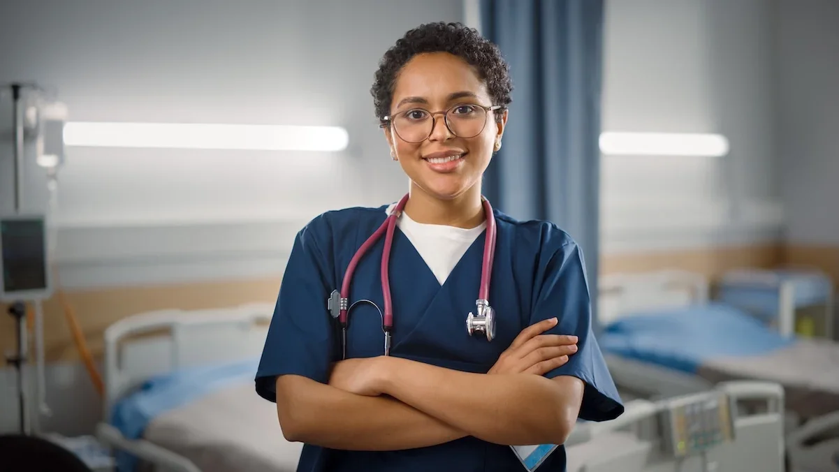 caregiver standing in front of hospital bed